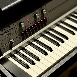 Elektronický klavír v černém plastovém pouzdře s bílými a černými klávesami. Na ovládacím panelu je nápis Wersi PIANOSTAR T 2000 a přepínač s označen…