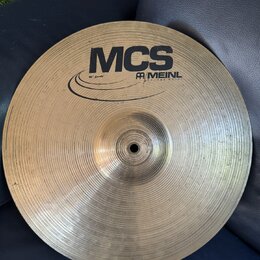 Kruhový mosazný činel s viditelným rýhováním povrchu. Na horní straně je černý nápis MCS a logo MEINL s doplňujícím textem 1953 AND MUSIC. Vlevo od l…