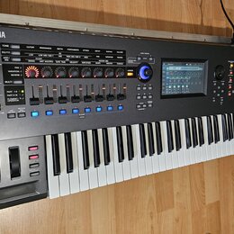 Černý digitální syntezátor s klávesnicí. Na levé straně horního panelu je logo a nápis YAMAHA, na pravé straně nápis MONTAGE. Přístroj obsahuje numer…