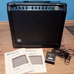 Černý kytarový kombozesilovač s látkovým předním krytem a ovládacím panelem v horní části. Na panelu jsou nápisy Stage Line, GA-1240R PRO GUITAR AMPL…