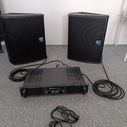 Dva černé reproduktory s mřížkami a modrými logy „dB Technologies“. Mezi nimi je umístěn černý rackový zesilovač s nápisem „skytec PRO244“ a „AMPLIFI…