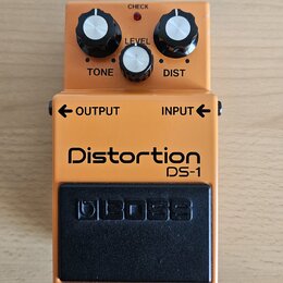 Kytarový efekt v oranžovém provedení s černým spínacím pedálem. Na šasi jsou nápisy Distortion, DS-1 a na pedálu logo BOSS. Horní část obsahuje tři o…