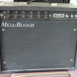 Černý kytarový kombozesilovač s látkovým předním krytem. Na krytu je bílý nápis Mesa/Boogie a v horním ovládacím panelu se nachází logo MESA. Panel o…