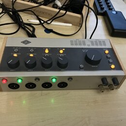 Stříbrno-černý rackový procesor v dřevěném rámu. Na horním panelu je logo UA a nápisy 76 COMPRESSOR u čtyř ovládacích knoflíků GAIN, vedle nich je oz…