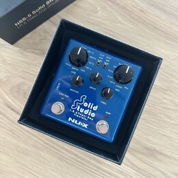 Modrý efekt pedál značky NUX s nápisem Solid Studio I.R. & Power Amp Simulator. Zařízení má tři ovládací knoflíky s popisky MASTER, DRIVE a PRES., př…
