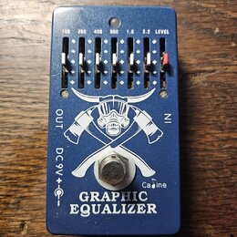 Modrý kytarový efekt s nápisem GRAPHIC EQUALIZER a logem znázornujícím plynovou masku s křížovými trubkami. Na horní straně jsou posuvníky s označení…
