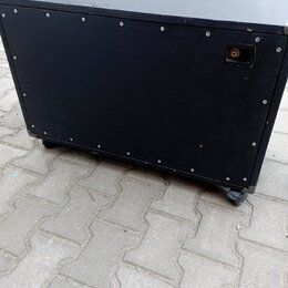 Černý obdélníkový reproduktorový box s povrchem z textilie. Na zadní straně je umístěn jeden konektor pro kabel a v horní části horního panelu je výř…