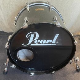 Černý basový buben s kovovým kováním a opěrnými nožkami. Na předním černém krytu je bílý nápis Pearl®. V horní části korpusu je umístěna malá zlatá t…