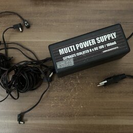 Černý obdélníkový zdroj napájení s několika připojenými kabely a konektory. Na horní straně je bílý nápis MULTI POWER SUPPLY a pod ním text SEPARATE…