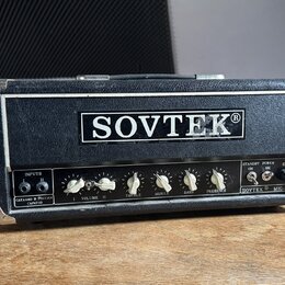 Kytarový zesilovač v černém vinylovém potahu s kovovými hranami. Na předním panelu je velký nápis SOVTEK® a vpravo dole označení SOVTEK® MIG-50. Vlev…