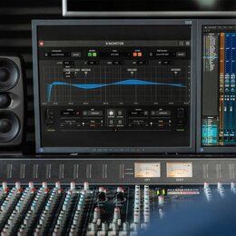 Fotografie zachicuje studiové vybavení zahrnující míchací pult značky ALLEN&HEATH model R24, černý studiový monitor s dvěma reproduktory a dva počíta…