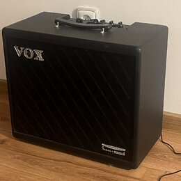 Černý kytarový kombozesilovač s texturovaným povrchem a černou přední síťovkou. V horní levé části je umístěno stříbrné logo VOX a v pravém dolním ro…
