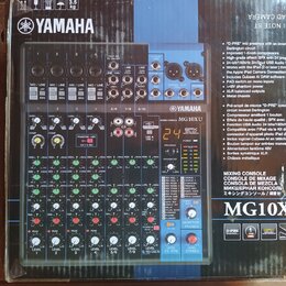Fotografie zobrazuje míchací pult Yamaha MG10XU v původním kartónovém obalu. Na přístroji je viditelné logo YAMAHA a označení modelu MIXING CONSOLE M…