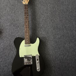 Černá elektrická kytara typu Telecaster s bílým pickguardem a hnědým hmatníkem. Na hlavě kytary je viditelné logo "Ariari". Nástroj vykazuje známky b…