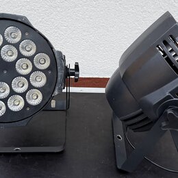 Dvě černé světla na stojáncích. Levý přístroj je kulatý s 18 LED diodami v mřížce, pravý přístroj má kompaktní hranatý tvar s ventilačními otvory. Na…