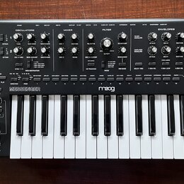 Černý analogový syntetizátor s bílými klávesami. Na předním panelu jsou rozloženy knofíky a přepínače v sekcích LFO 1, OSCILLATORS, MIXER, FILTER, EN…