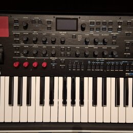 Černý klávesový syntetizátor s bílými klávesami. Na levé straně je logo KORG a na pravé nápis modwave mkII WAVE TABLE SYNTHESIZER. Horní panel obsahu…