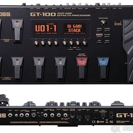 Fotografie zobrazuje efektový procesor Boss GT-100 v černé barvě. Na horní straně je nápis BOSS GT-100 AMP EFFECTS PROCESSOR, displej s textem U01-1…