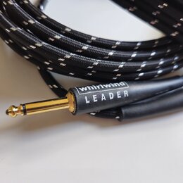 Černý pletený kabel s pozlaceným konektorem. Na černé části konektoru je bílý nápis whirlwind a pod ním slovo LEADER. Povrch kabelu i konektoru vypad…