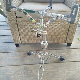 Chromovaný stojan s černými plastovými držáky. Na středovém uzamykacím mechanismu je viditelné logo Pearl. Povrch chromu vykazuje mírné opotřebení a…