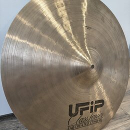 Kruhové činely z mosazi s viditelným broušením povrchu. Na spodní části je černé logo UFIP, pod ním nápis Class series a text EARCREATED CYMBALS. V h…