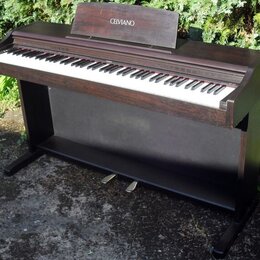 Digitální piano v tmavě hnědé dřevěné provedení s černým spodním panelem. Na horním stojáku na noty je bílý nápis CELVIANO a vpravo nad klávesami je…
