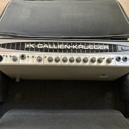 Stříbrný basový zesilovač v černém přepravním kufru. Na horním panelu je nápis GALLIEN-KRUEGER s logem GK a označení 1001RB. Přední panel obsahuje ná…