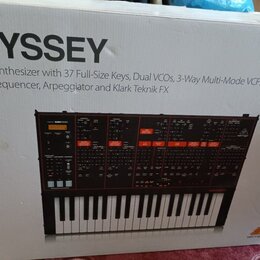 Fotografie zachycuje kartonovou krabici s obrázkem analogového syntetizátoru. Na krabici je velký nápis ODYSSEY a text Analog Synthesizer with 37 Ful…
