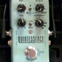 Světle modrý efekt pedál s nápisy QUINTESSENCE HARMONY a tc electronic. Na horní části jsou tři černé otočné ovladače s popisky KEY, SCALE a MIX, dál…