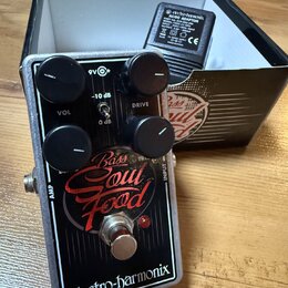 Černý efekt pedál s bílým lemováním a nápisy Bass Soul Food a electro-harmonix. Na horní části jsou čtyři černé ovládací knoflíky a přepínač s označe…