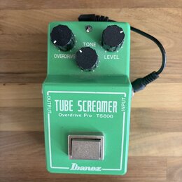 Zelený efekt pedál s nápisy TUBE SCREAMER, Overdrive Pro TS808 a logem Ibanez. Na horní straně jsou tři černé ovládací knoflíky s popisky OVERDRIVE,…