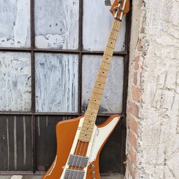 Hnědá elektrická basová kytara s bílým pickguardem a světlou hnedou hmatníkem. Na těle je vidět nápis "Eagle" a dva humbuckery s kovovými kryty. Lak…