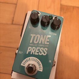 Tyrkysový efekt pedál s bílými nápisy. Na horní straně jsou tři černé oválné knoflíky s popisky VOLUME, BLEND a SUSTAIN. Uprostřed je velký bílý nápi…