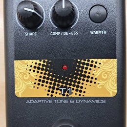 Černý efekt pedál s nápisy TC HELICON a VOICETONE. Na horní části jsou dva černé otočné ovladače s popisky SHAPE a COMP / DE-ESS a jedno tlačítko WAR…