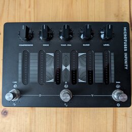 Černý kytarový efekt s nápisem MICROTUBES INFINITY. V horní části jsou pět otáčivých ovladačů s popisky COMPRESSION, DRIVE, TONE • ERA, BLEND a LEVEL…