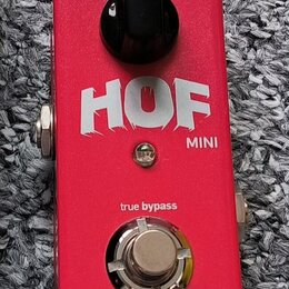 Červený kytarový efekt pedál s nápisem HOF MINI. Na horní straně je černý otočný knoflík s označením RE 3, ve spodní části je stříbrný spínací tlačít…