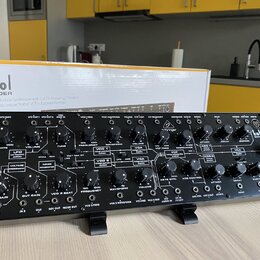 Černý analogový semi-modulární syntetizátor s nápisem kobol EXPANDER. Přední panel obsahuje zahlreiche ovládací knofíky, přepínače a zapojovací konek…