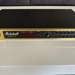Zlatý rackový předzesilovač s černým krytem. Na čelním panelu je bílé logo Marshall a nápisy VALUE MIDI PRE-AMP JMP-1. Zařízení má červený digitální…