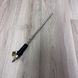 Kovový nástroj s dlouhou, tenkou hřídelí a černou rukojetí. Spodní část je vybavena mosazným mechanismem s malým šroubem a hrotem. Na předmětu nejsou…