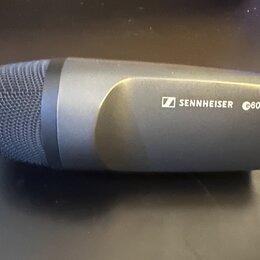 Šedý dynamický mikrofon s kovovou síťkou. Na těle je bílý nápis SENNHEISER s logem a označení e602-II. Povrch mikrofonu je matný a v dobrém stavu.