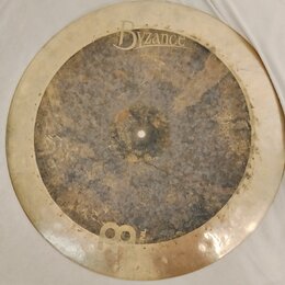 Kruhový mosazný činel s výrazně patinovaným a tmavším středem. V horní části je vidět nápis Byzance a pod ním menší text Made in China. Povrch činelu…