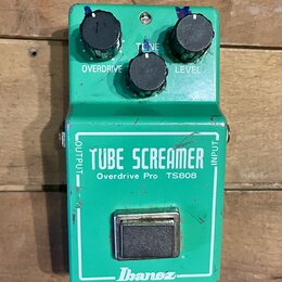 Zelený efekt pedál s nápisy TUBE SCREAMER, Overdrive Pro TS808 a logem Ibanez. Na horní části jsou tři černé ovládací knoflíky s popisky OVERDRIVE, T…