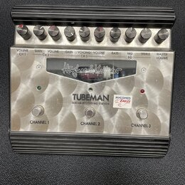 Stříbrný kytarový předzesilovač s černým žebrovaným rámem. Na čelním panelu je nápis „Hughes & Kettner“, modelové označení „TUBEMAN GUITAR RECORDING…