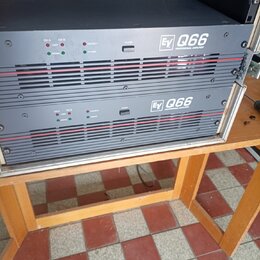 Dvě černé rackové koncové stupně s červenými vodorovnými liniemi na předním panelu. Na obou zařizeních je bílý nápis „Ev Q66 PROFESSIONAL AMPLIFIER“.…
