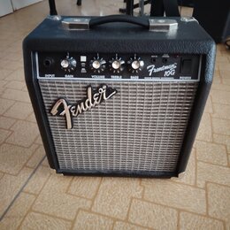 Černý kytarový kombo zesilovač s šedou textilní maskou reproduktoru. Na předním panelu je nápis Fender a označení modelu Frontman 10G s doplňkem FEND…