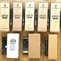 Fotografie zobrazuje sadu modulárních syntetizátorů v krabicích a bez nich. V horní řadě jsou pět krabic značky erica synths s moduly pico VCT3, QUAN…