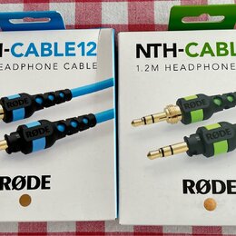 Dvě krabičky s nápisy NTH-CABLE12 a 1.2M HEADPHONE CABLE. Na obalech je logo RØDE a fotografie kabelů v modré a zelené barvě. Krabičky jsou bílé s ba…