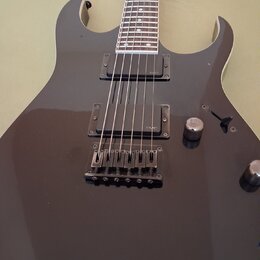 Černá elektrická kytara s dvojitým výřezem v korpusu. Nástroj je vybaven dvěma humbuckery s nápisem EMG a černým mostem. Na korpusu jsou umístěny dva…
