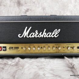 Kytarový kombozesilovač značky Marshall v černém vinylovém potahu s bílým logem Marshall na předním textilním krytu. Zlatý ovládací panel nese nápisy…