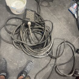 Na fotografii je zmotaný šedý kabel s připojeným černým ovládacím boxem. Box obsahuje 12 tlačítek a nápisy „SMLART“, „TX“ a „RX“. Povrch kabelu i box…